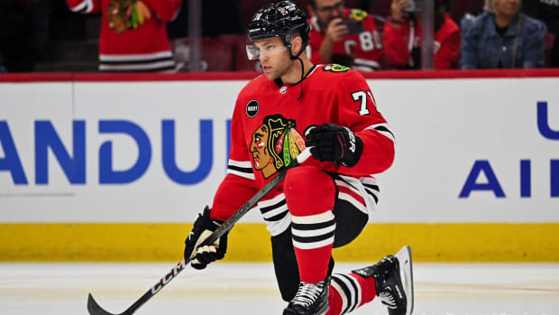 Blackhawks forward Taylor Hall kneels on the ices before a game.